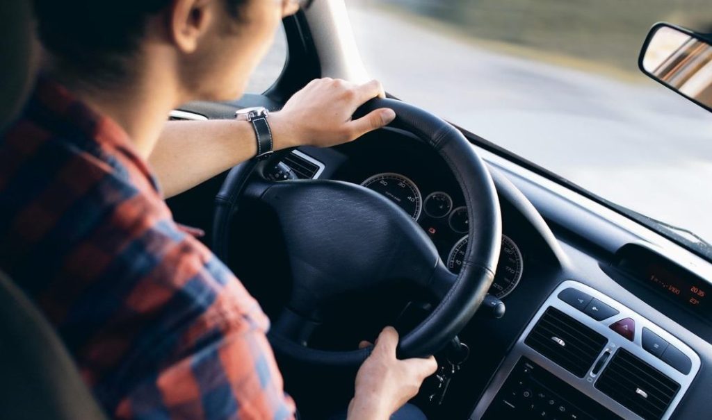 Bestuurder die zich voorbereidt op het praktische rijexamen met mentale focus en verkeersaandacht