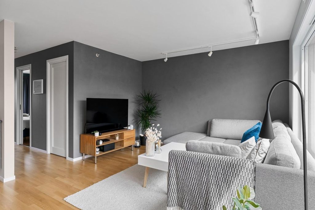 Moderne strakke wand met verlichting, wandplanken en warme materialen voor een sfeervolle inrichting